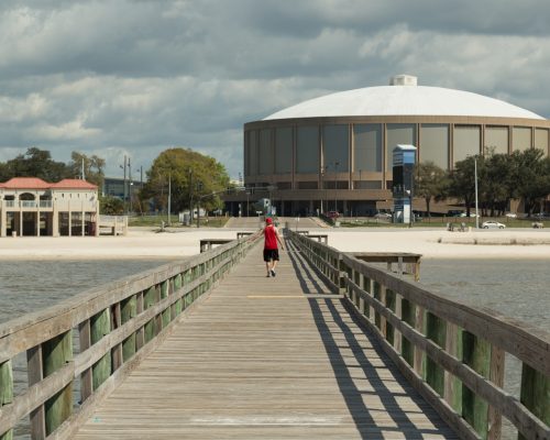 Mississippi Coast Coliseum Pier A photograph of an anonymous person from behind on the Mississippi Coast Coliseum Pier, Biloxi, Mississippi, USA. Mississippi Coast Coliseum is an 11,500-seat reserved seating, 15,000 festival seating, multi-purpose arena in Biloxi, Mississippi. It was built in 1977. It hosted WCW Beach Blast 1993 and the Sun Belt Conference men’s basketball tournament in 1992 and 1993. The Metro Conference men's basketball tournaments were contested there in 1990 and 1994. The first concert held at the Mississippi Coast Coliseum was by the rock band Foghat on April 27, 1978. The Mississippi Coast Coliseum also holds one of the largest crawfish festivals in America. This event is held every year, over two weekends in April.